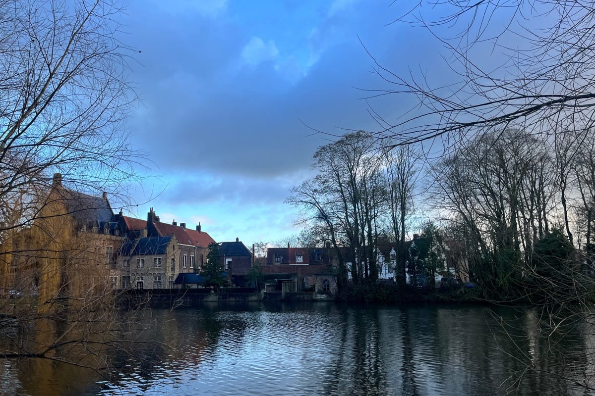 “Scenic Belgian riverside framed by lush trees under a clear blue sky — serene landscapes and refined European charm, TripsWithSam Belgium itinerary.”