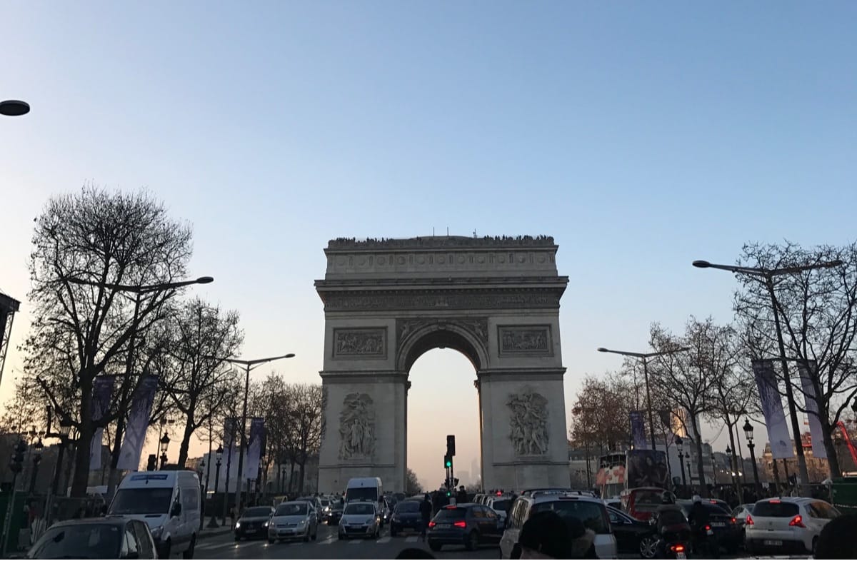 “Arc de Triomphe illuminated at dusk, symbolizing Parisian elegance and timeless French luxury – Travel Itineraries by TripsWithSam France itinerary.”