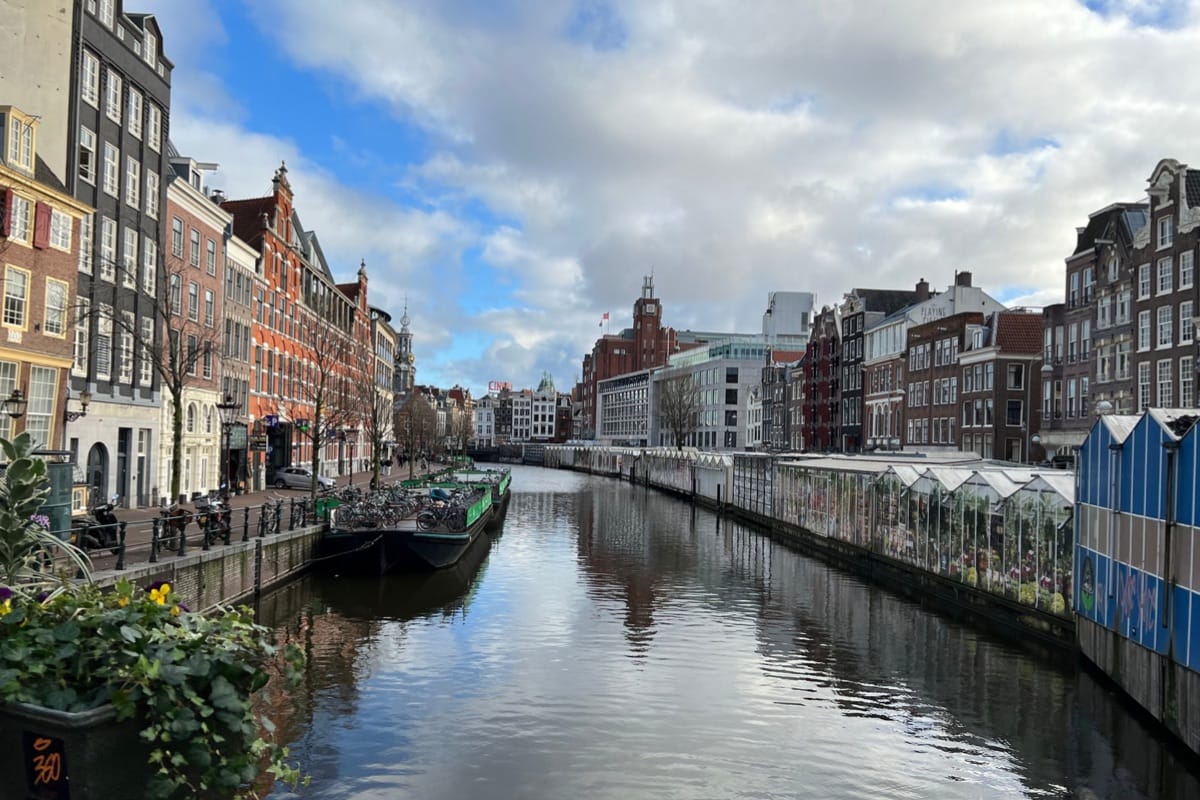 “Picturesque canal in Amsterdam flanked by historic Dutch houses — serene waterways, charming bridges, and luxury Netherlands travel, TripsWithSam Holland itinerary.”