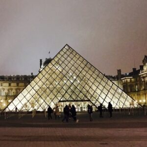 Evening view of the Louvre courtyard in Paris, glowing under a golden sky — where art and history meet timeless elegance.