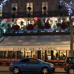 Classic Parisian café scene at Café de Flore in Saint-Germain-des-Prés — marble tables, warm light, and quiet sophistication.